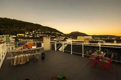 a balcony with a table and chairs and a view of a city at Torgalmenningen Town Square, Yet quiet, Elevator in building in Bergen