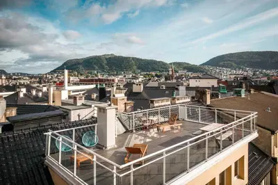 a balcony with chairs and tables on top of a building at Torgalmenningen Town Square, Yet quiet, Elevator in building in Bergen