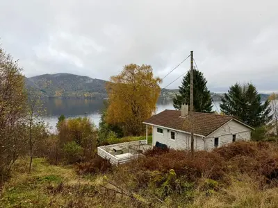 a house on a hill next to a body of water at Fjordview retreat in Hamre