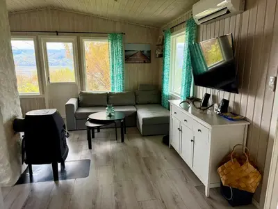 a small living room with a couch and a tv at Fjordview retreat in Hamre
