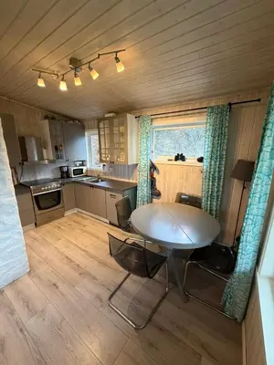 a kitchen with a table and chairs in a room at Fjordview retreat in Hamre