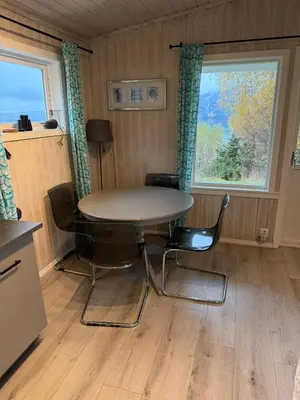a table and chairs in a room with a window at Fjordview retreat in Hamre