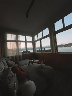 a living room with windows and a couch at Toppleilighet i sentrum av øystese in Kvam