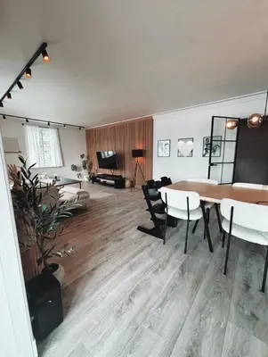 a large living room with a table and chairs at Toppleilighet i sentrum av øystese in Kvam