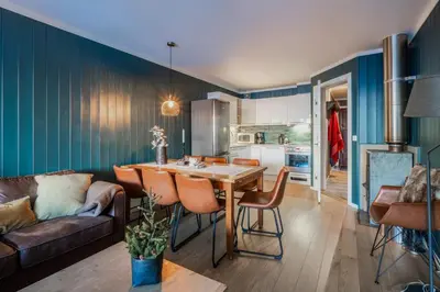 a kitchen and living room with a table and a couch at Ski in-Ski out and True Mountain Charm in Hemsedal