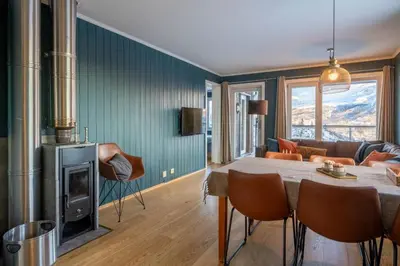 a living room with a table and a fireplace at Ski in-Ski out and True Mountain Charm in Hemsedal