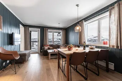 a living room with a table and a couch at Family-Friendly Ski in-Ski out Retreat by Skarsnuten in Hemsedal