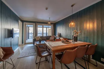 a living room with a wooden table and a couch at Family-Friendly Ski in-Ski out Retreat by Skarsnuten in Hemsedal