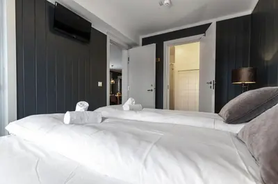two large white beds in a room with a television at Ski in-Ski out with Style and Scenic Views in Hemsedal