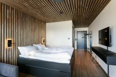 a bedroom with a large bed with a wooden ceiling at Rosenlund Hamn in Sande