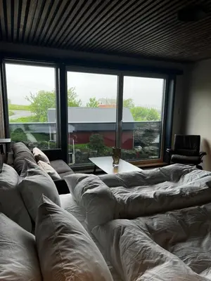 a living room with a couch and a large window at Rosenlund Hamn in Sande