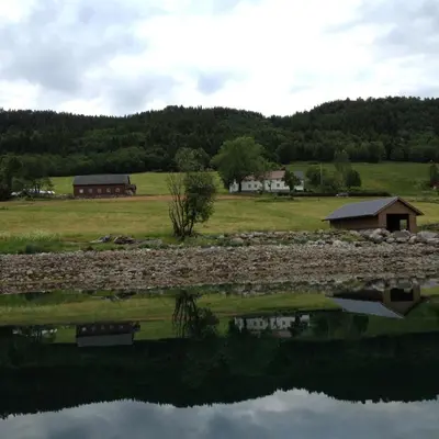 a reflection of a house in a body of water at Strand farm, sea view and boat rental in Averoy