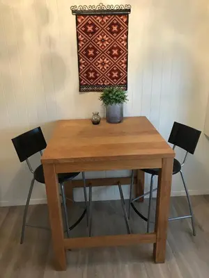 a wooden table with two chairs and a potted plant at Strand farm, sea view and boat rental in Averoy