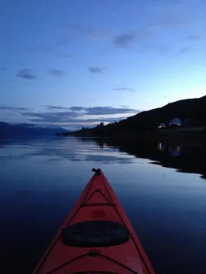 a red kayak on a lake at night at Strand farm, sea view and boat rental in Averoy