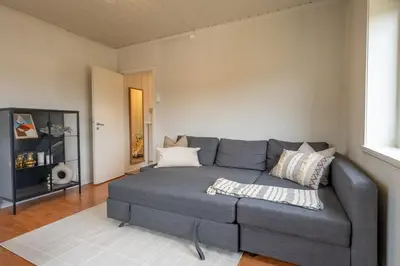 a living room with a gray couch in a room at Small house close to nature and city in Bergen
