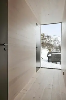 a door to a room with a view of a snow covered yard at New Cabin With Panoramic Views At Hardangervidda in Eidfjord