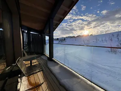a balcony of a house with a view of the snow at Kikut Alpin Lodge 1302 in Geilo