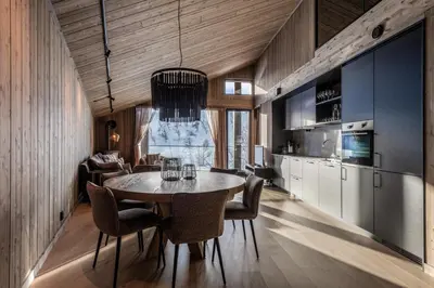 a kitchen and dining room with a table and chairs at Kikut Alpin Lodge 1302 in Geilo