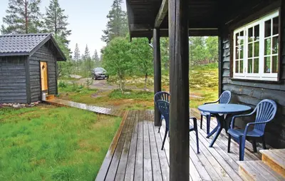 a porch with a table and chairs on a house at Cozy Home In Rendalen With Sauna in Akrestrommen