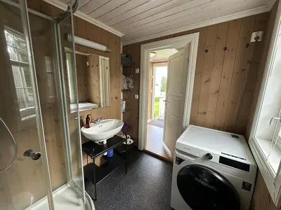 a bathroom with a sink and a washing machine at Koselig vestlandshus ved fjorden in Holmedal