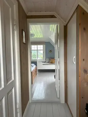 a hallway leading to a room with a bed at Koselig vestlandshus ved fjorden in Holmedal