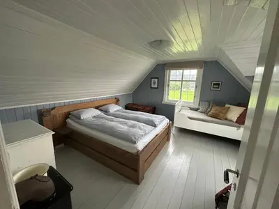 a bedroom with two beds in a room with a attic at Koselig vestlandshus ved fjorden in Holmedal