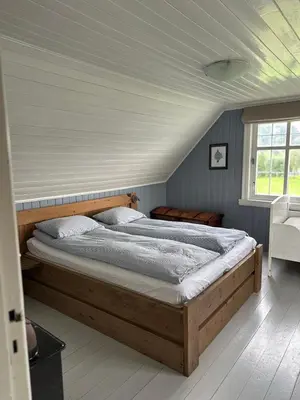 a bedroom with a large bed in a room at Koselig vestlandshus ved fjorden in Holmedal