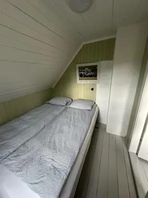 a small bedroom with a bed in a room at Koselig vestlandshus ved fjorden in Holmedal