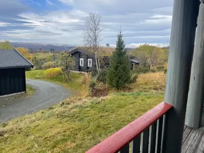a view from a balcony of a house with a road at Koselig og sentral hytte med peis og badstue in Beitostøl