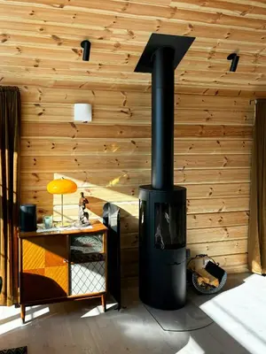 a fireplace in a room with a wooden wall at Mountain Cabin With Panoramic Views In Valdres in Etnedal