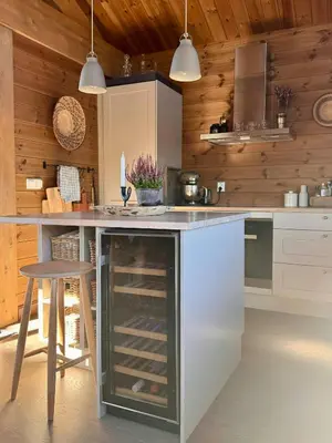 a kitchen with wooden walls and a counter with stools at Apartment With Panoramic Views In Beitostølen in Beitostøl