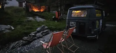 two chairs and a van in a yard at night at Retro & Vintage Camping in Vaksdal