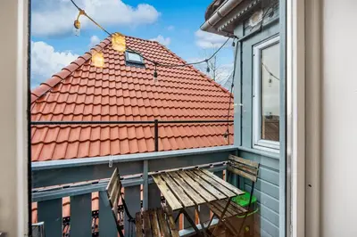 a balcony with a bench and a red roof at THIS IS BERGEN, 2 min walk to everything in Bergen