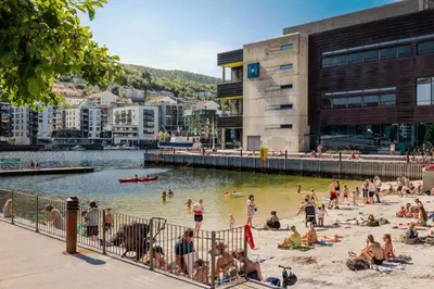 a group of people on a beach near a body of water at Brand New & High-End 3 Bedrooms 2 Bathrooms Central Apartment in Bergen