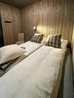 a large white bed in a room with wooden walls at Modern Apartment In The Heart Of Hovden in Hovden