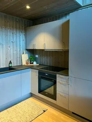 a kitchen with stainless steel appliances and wooden cabinets at Modern Apartment In The Heart Of Hovden in Hovden
