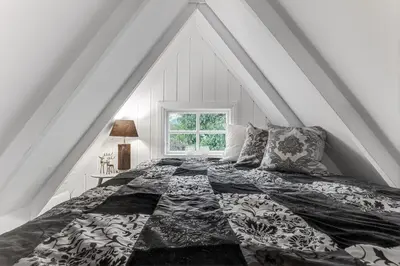 a bedroom with a large bed with a window at Lysthuset den lille villa - authentic wodden house in Bergen