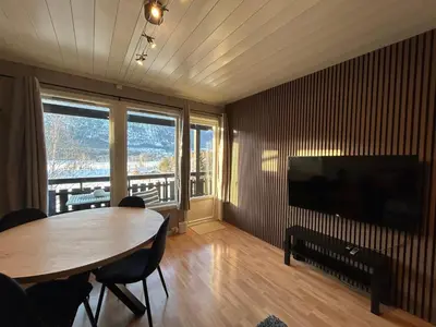 a living room with a table and a large television at Hafjell Ski-in Ski-Out in Øyer