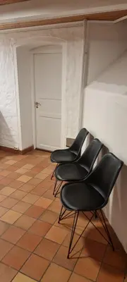 a row of black chairs sitting in a room at Big and cozy room in the middle of the city in Trondheim