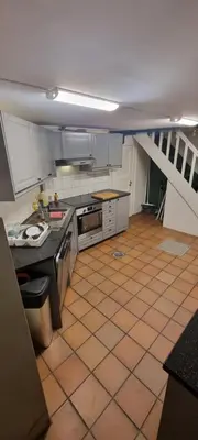 a kitchen with a staircase in the middle of a room at Big and cozy room in the middle of the city in Trondheim