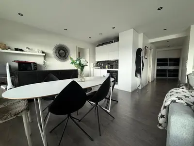 a kitchen and living room with a table and chairs at Villa med 5 soverom, 4 bad og 3 kjøkken, 400 m fra lokal badestrand in Bergen