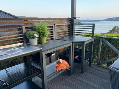 a table and two chairs on a deck at Villa med 5 soverom, 4 bad og 3 kjøkken, 400 m fra lokal badestrand in Bergen