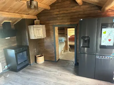 a kitchen with a refrigerator and a door to a bedroom at Bottheimsætra