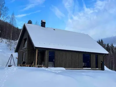 a cabin with snow on the roof in the snow at Nice cabin at Norefjell skicenter in Noresund