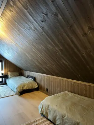 two beds in a room with a wooden ceiling at Nice cabin at Norefjell skicenter in Noresund