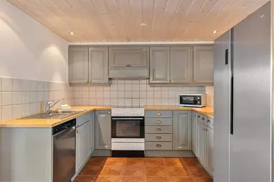 a kitchen with white cabinets and stainless steel appliances at Trysilfjell 752E by Vacation Trysil in Trysil