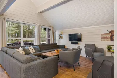 a living room with a couch and chairs and a tv at Alpingrenda 38B by Vacation Trysil in Trysil