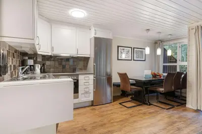 a kitchen with a table and a refrigerator at Alpingrenda 38B by Vacation Trysil in Trysil