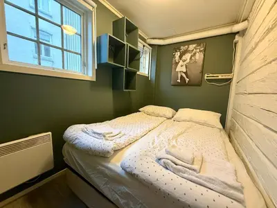 a small bed in a room with a window at Rustic Retreat Apartment, Central & free parking ! in Trondheim