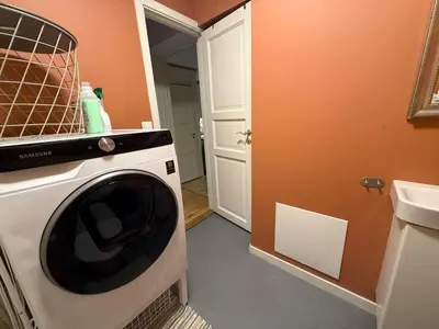 a kitchen with a washing machine in a room at Rustic Retreat Apartment, Central & free parking ! in Trondheim